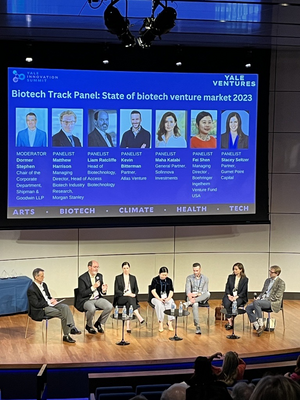 panel sitting on stage and talking to audience 