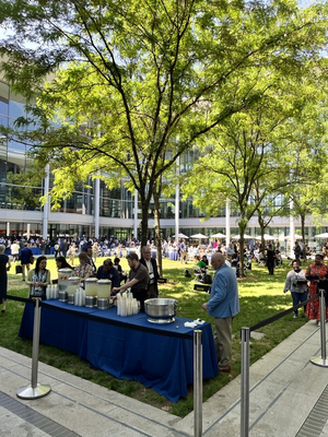 people standing and eating a reception in courtyard of the School of Management 