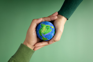 5 ways to make your next event carbon neutral article, two hands holding replica of the earth
