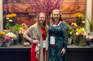 Two YC&E staff members, Sam Iucci and Emily Roback. Smiling at a conference.