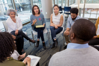 Office staff in a circle, talking to one another