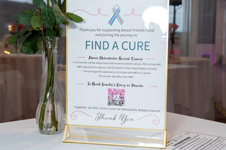 Picture of "Find a Cure" sign on table next to flowers 