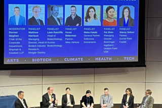 panel sitting on stage and talking to audience 