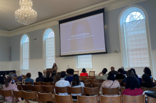 Room of people listening to a speaker 