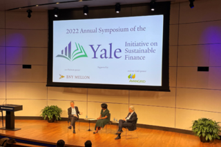 3 People sitting in chairs on the stage in Zhang Auditorium 