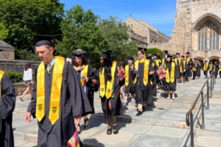 Class of 2022 walking in front of Sterling Memorial Library