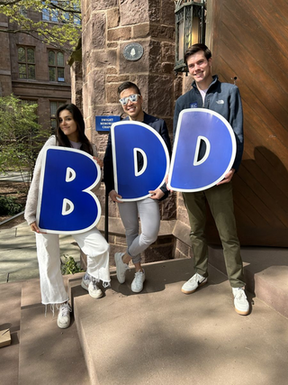 Three Students holding the letters " B D D" 