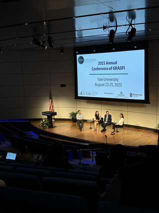 Global Research Alliance for Sustainable Finance and Investment Conference: Panel on stage with low-lighting