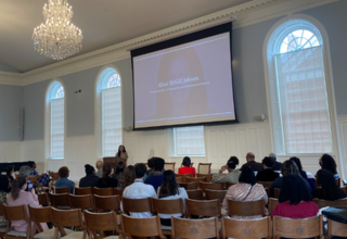 Room of people listening to a speaker 