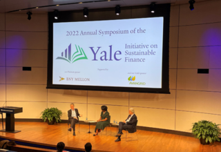 3 People sitting in chairs on the stage in Zhang Auditorium 