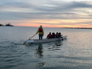 Man and friends on a canoe watching the sunset